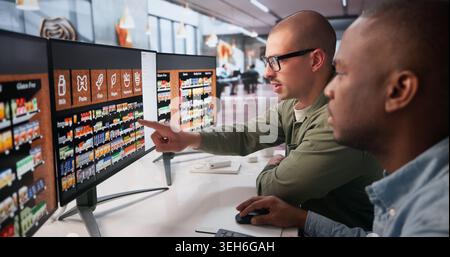Two Retail Managers Working Together On Computer To Plan Store Layout. Stock Photo