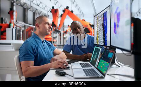 Young Automotive Engineer Uses 3D Simulation Software Analyzing Electric Vehicle Structure. Stock Photo