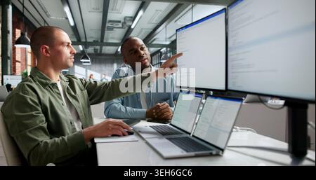 Two Software Engineers Working Together On Secure Web Application Code. Stock Photo