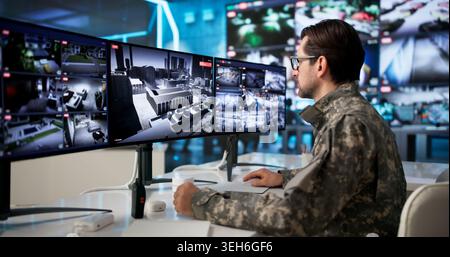 Military Man Uses Computer Screens To Monitor Government Security Systems. Stock Photo