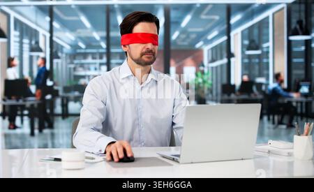 Blindfolded Businessman Typing Focused On Laptop, Solving Problems At Desk. Stock Photo