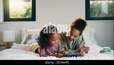 Relax, children or girls with tablet in bedroom, watch cartoon or streaming video for weekend bonding. Family subscription, movie website or sisters Stock Photo