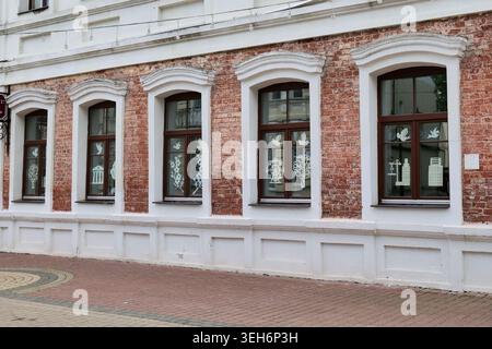 Red Brick Building Facade with Two Windows and White Sills Stock Photo
