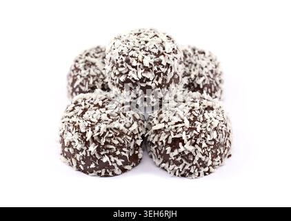 Cocoa balls with oatmeal covered with rasped coconut on white background. Stock Photo