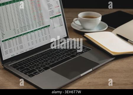 Laptop displaying spreadsheet documents with financial tables and online business reports on workspace desk, supporting data analysis, accounting work Stock Photo