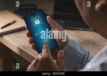 Person using smartphone with password and fingerprint authentication interface in office workspace, suitable for banking security, payment protection, Stock Photo