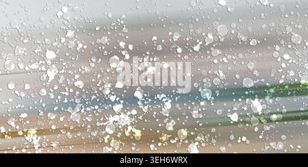 An abstract background featuring a muted grey and earthy tone gradient with scattered white paint splatters and subtle light streaks. Stock Photo