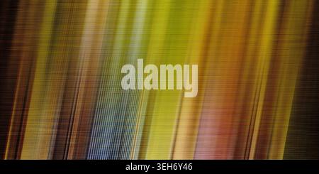 A vibrant abstract background with a fine linen texture and dynamic motion blur in shades of yellow, gold, green, orange, and blue. Stock Photo