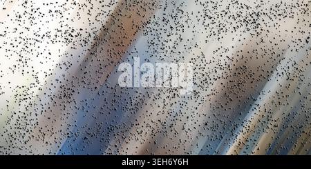 A textured abstract background featuring a gradient of light blue, grey, and beige diagonal light streaks overlaid with a pattern of scattered, small Stock Photo