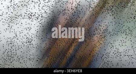 An abstract composition featuring dynamic diagonal motion blur streaks in metallic tones, overlaid with a layer of small, dark, textured particles. Stock Photo