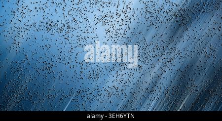 An abstract digital background featuring diagonal light streaks in shades of blue, overlaid with a textured pattern of small dark particles. Stock Photo