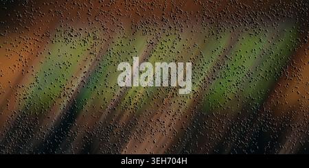 An abstract composition with a dark, textured surface covered in small particles, accented by diagonal streaks of green and brown light. Stock Photo