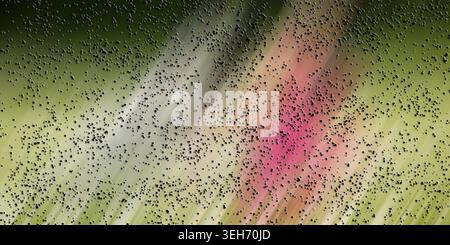An abstract composition with a diagonal motion blur in shades of green and pink, covered by a layer of small, dark, textured particles. Stock Photo
