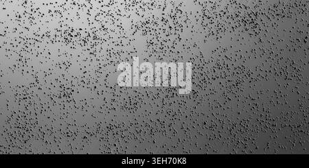 A high-resolution abstract background featuring a metallic silver texture with numerous small, dark, randomly scattered particles creating a depth eff Stock Photo