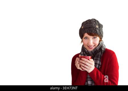 Red ceramic mug is being held near chest on right side against white backdrop, copy space Stock Photo