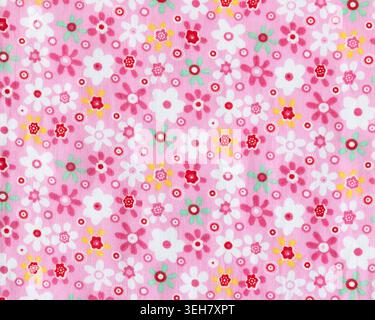 Textured floral fabric with a predominantly pink hue, featuring small, colourful and varied flowers Stock Photo
