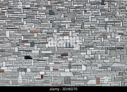 Exterior wall coating made of different size multicolor stone tiles randomly arranged. Background and texture. Stock Photo