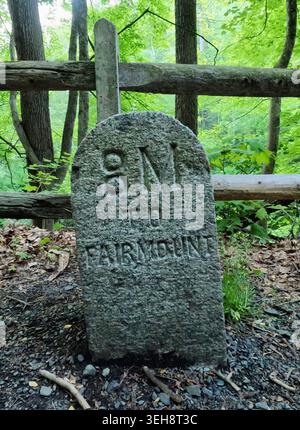 A carved marker notes eight miles to Fairmount along Forbidden Drive in Wissahickon Valley Park in Philadelphia, PA. Stock Photo
