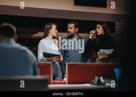 Business colleagues discussing project plans and strategy in a modern office meeting space Stock Photo