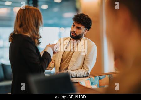 Business conversation between two colleagues in a modern casual office lounge discussing ideas Stock Photo