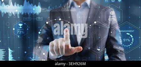Business professional interacting with a digital interface displaying data analytics and business metrics representing modern technology and managemen Stock Photo