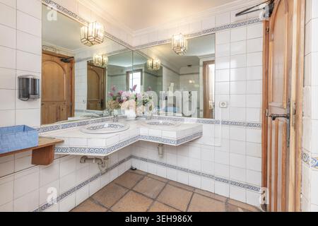 A double vanity with ample interior storage and fabric-covered fronts in neutral tones transforms the master bathroom into a haven of comfort and styl Stock Photo