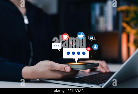 Social media marketing and online engagement concept. Woman using smartphone with virtual chat bubbles, likes, hearts, comments, user icons, email Stock Photo
