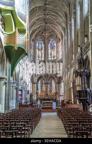 Interior view of Saint-Pierre Church in Caen. The photo shows the central nave with wooden chairs, elaborate ribbed vaulting on the ceiling, the high Stock Photo