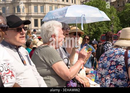London, UK. 23rd May 2026. UK Weather,  The UK Health Security Agency issued its first amber heat-health alert of 2026 for London on 22 May, in place until 27 May, as temperatures were forecast to reach 30°C — potentially breaking the UK May temperature record. A participant in the Ichthus Christian Fellowship Jesus March sits beside the fountain at Trafalgar Square, central London,  shelters beneath a white umbrella used as a sun parasol  .  Credit:xiu bao/Alamy Live News Stock Photo