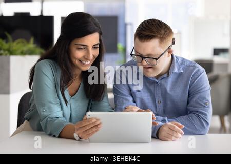 Diverse coworkers collaborating with digital tablet in office Stock Photo