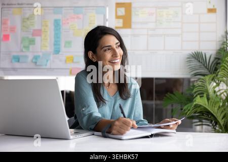 Brazilian woman makes notes, writing key moments into personal organizer Stock Photo