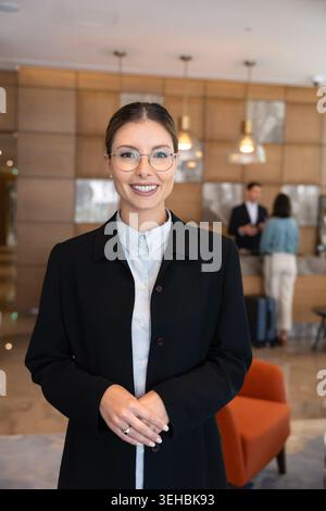 Portrait of smiling female receptionist standing in reception Stock Photo