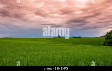 Dramatic sunset panorama of Cesky Raj landscape in Czech Republic with Trosky castle ruins on volcanic rocks beneath storm clouds glowing with sunset Stock Photo