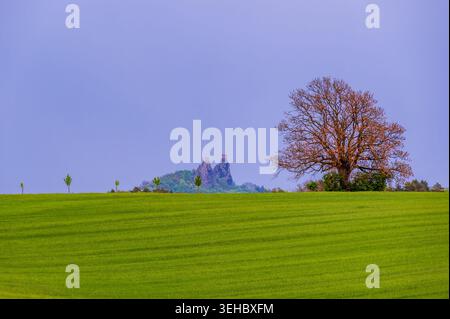 Dramatic evening panorama of Cesky Raj landscape in Czech Republic with Trosky castle ruins on volcanic rocks beneath dark storm clouds and deep blue Stock Photo
