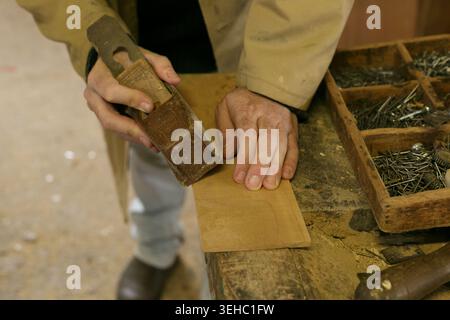 Skilled Craftsman Carefully Forms Detailed Wooden Parts Using Sanding Blocks And Handon Techniques Stock Photo