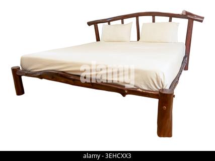 Two white pillows on wooden bed with mattress is isolated on white background with clipping path. Stock Photo
