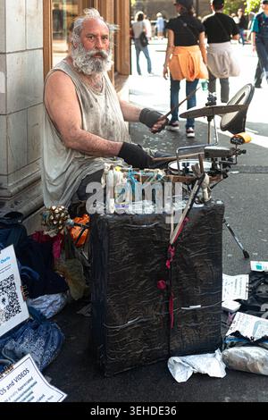 A handicapped elder drummer performing on the pavement, London, England, UK. Stock Photo