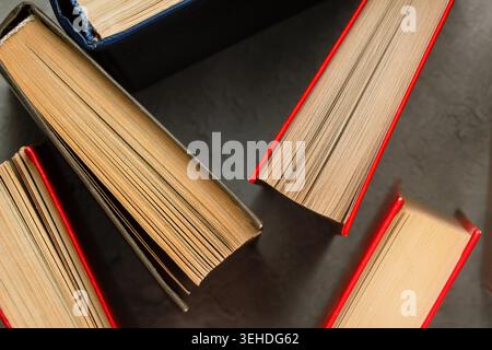 Stack of colorful books on dark background, top view educational pattern Stock Photo