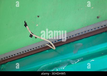 Exposed Electrical Cable Hanging From Ceiling With Damaged Roof Interior and Unsafe Wiring Condition Stock Photo