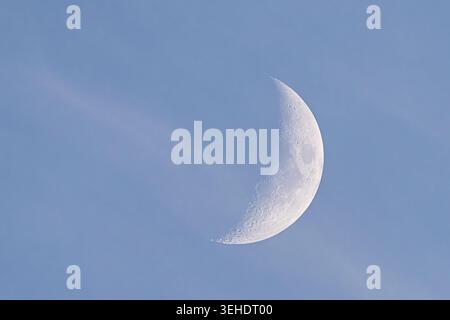 Gentle moonlit scene. Calm moonlight over pastel sky scene. Serene lunar glow blending with wispy clouds and gentle tones. Peaceful moon illuminated s Stock Photo