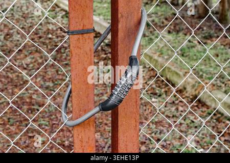 cable combination lock on the hanging gate Stock Photo