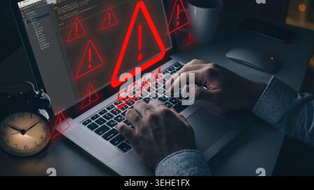 Warning about a scam message on a laptop with alarming symbols at night Stock Photo