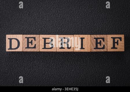 Food, The inscription debrief in wooden cubes on a dark concrete background. Can be used as part of your composition Stock Photo