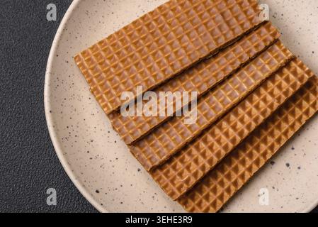 Food, Delicious sweet crispy rectangular waffles on a ceramic plate on a dark concrete background Stock Photo