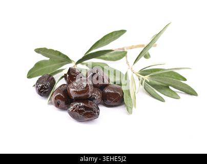 Dry salt cured black olives with leaves isolated on white background. Stock Photo
