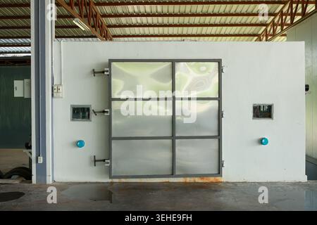 Industrial cold storage room with heavy duty metal door installed in warehouse building showing secure lock mechanism giving functional reliable impre Stock Photo
