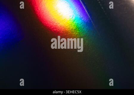 Vibrant Rainbow Reflections on Textured Dark Surface with Colorful Light Patterns Stock Photo