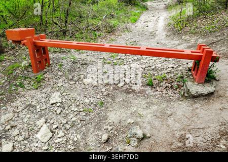 massive metal barrier on the road in the forest Stock Photo