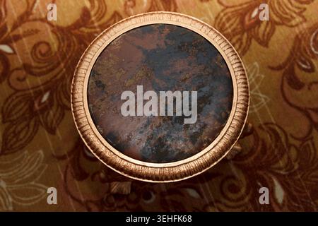 Round, metal chair, with a soft seat, made of leather of different shades. A patterned gold circle around seat, emphasizes the beautiful look after re Stock Photo