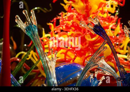 Close-up view of a vibrant glass art installation featuring delicate transparent tendrils with blue and teal bases in the foreground, set against a Stock Photo
